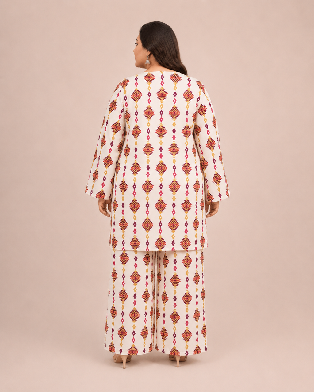 Back view of a plus-size model posing in a matching off-white and red geometric diamond printed cotton lawn kurta and wide trouser co-ord set.
