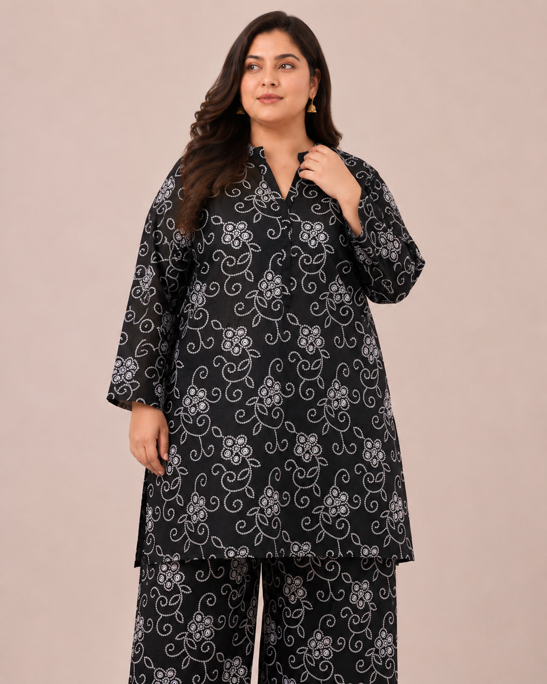 Front view of a smiling plus-size model posing in a matching black and white floral vine printed cotton lawn kurta and wide trouser co-ord set.