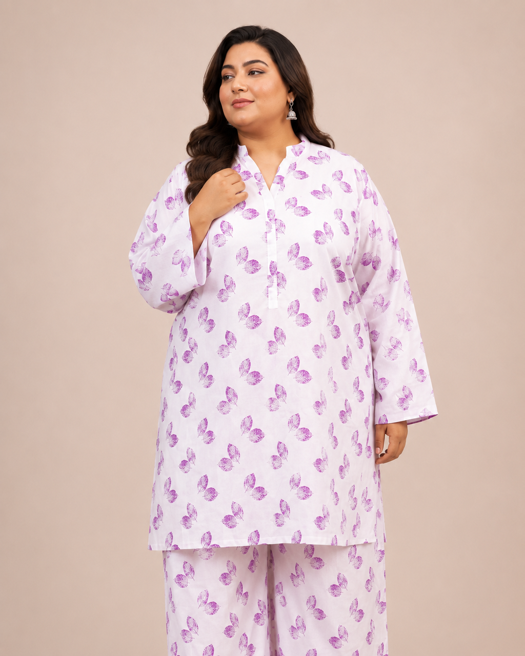 Front view of a smiling plus-size model posing in a matching white and lavender leaf printed cotton lawn kurta and wide trouser co-ord set.