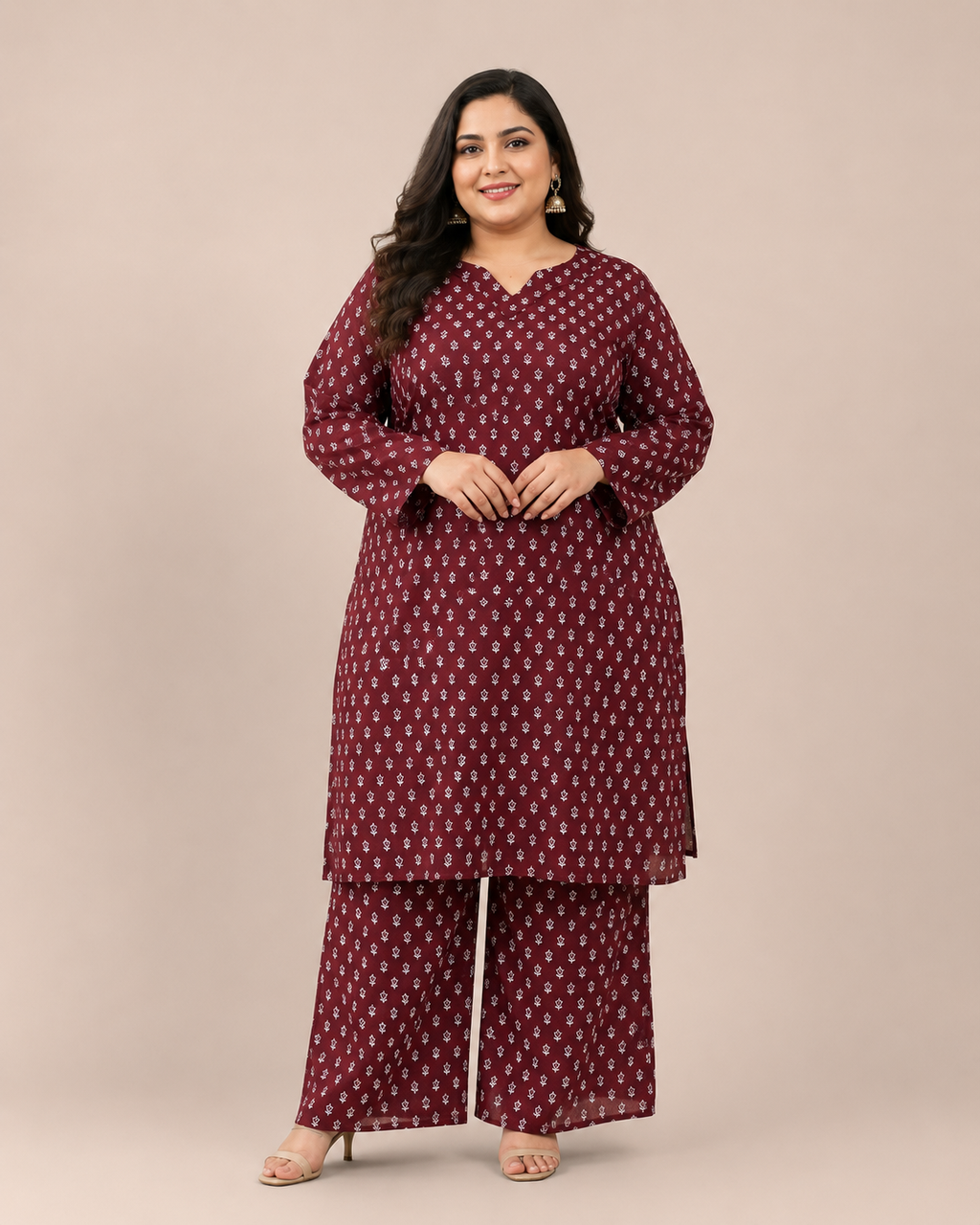 Front view of a smiling plus-size model posing in a matching deep maroon and white miniature floral printed cotton lawn kurta and wide trouser co-ord set.