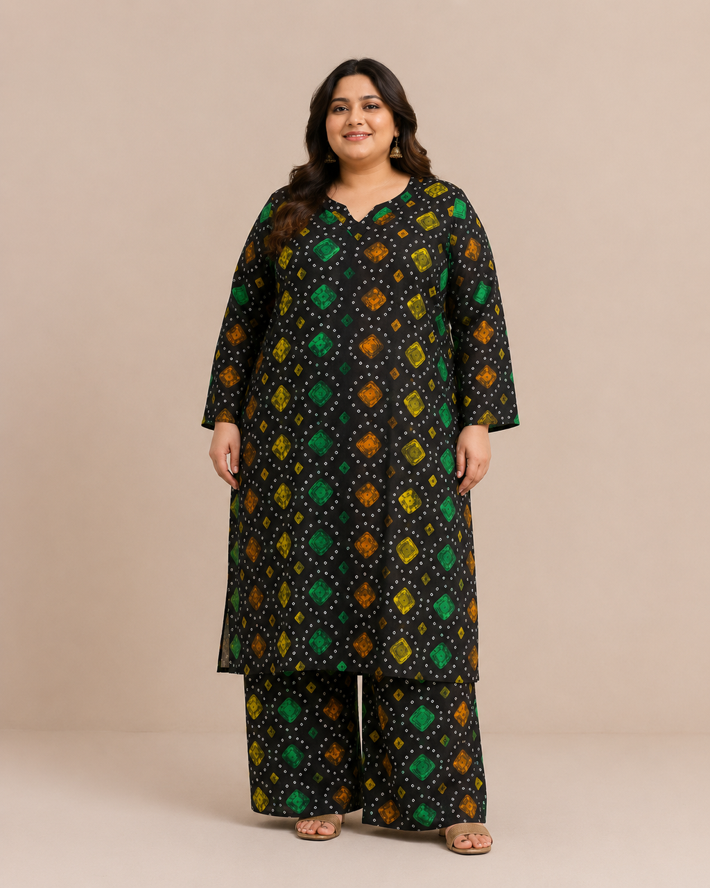 Front view of a plus-size model posing in a matching black, green, and orange multicolored chunri bandhani printed cotton lawn kurta and wide trouser co-ord set.