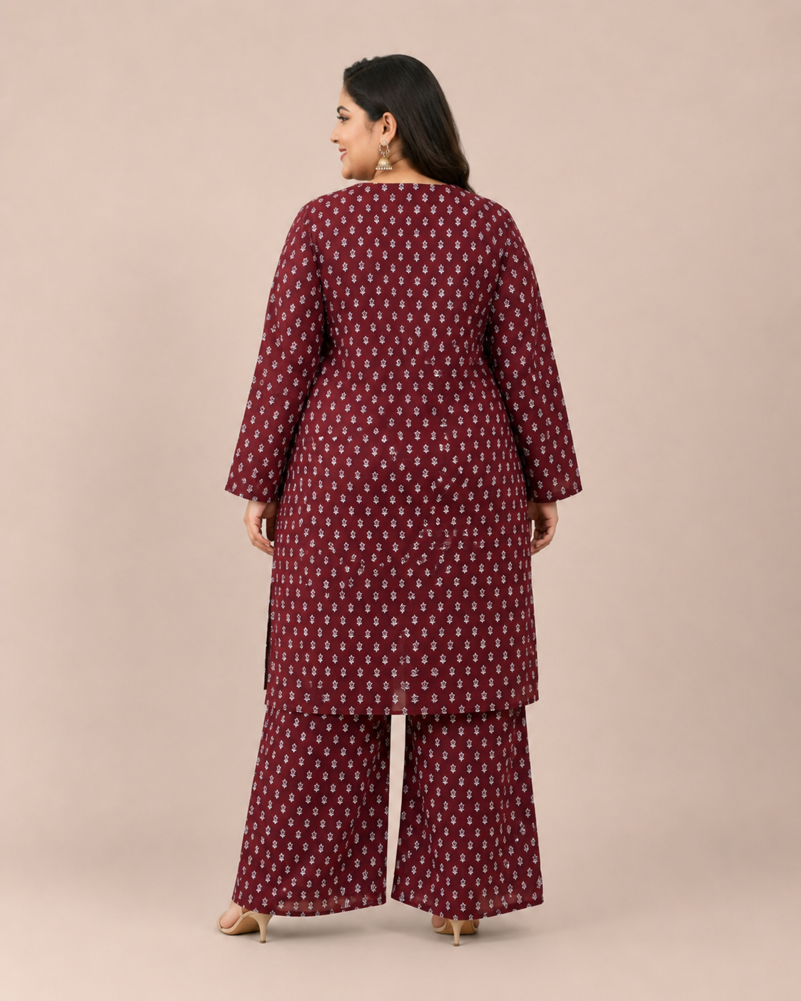 Front view of a smiling plus-size model posing in a matching deep maroon and white miniature floral printed cotton lawn kurta and wide trouser co-ord set.