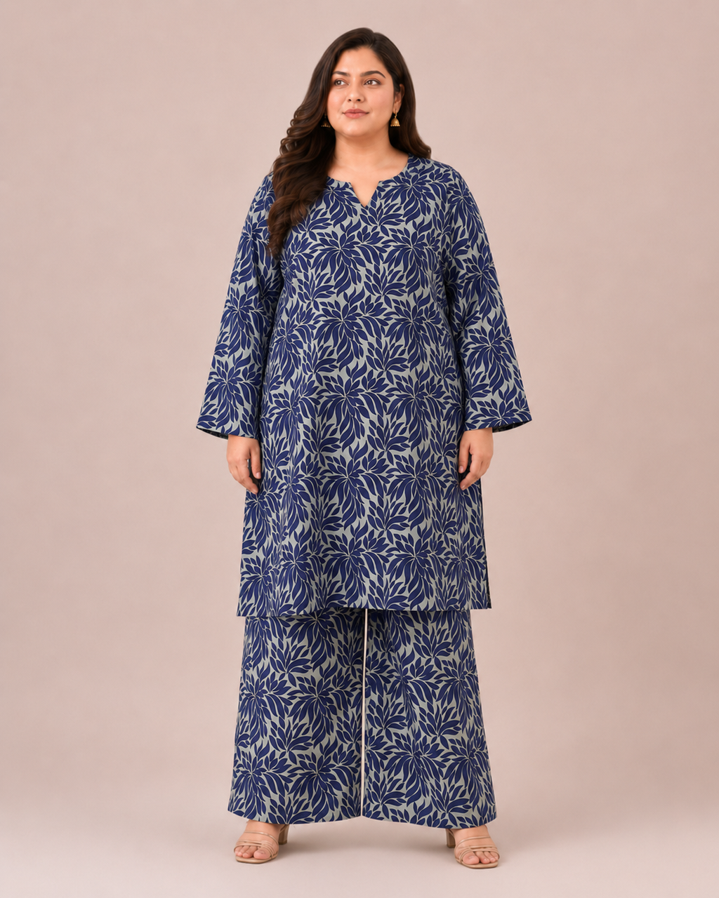 Front view of a plus-size model posing in a matching indigo blue and steel gray abstract leaf printed cotton lawn kurta and wide trouser co-ord set.